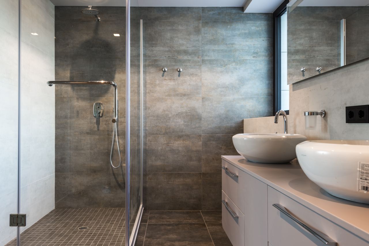 Stylish bathroom interior featuring ceramic sinks, glass shower, and elegant finishes.